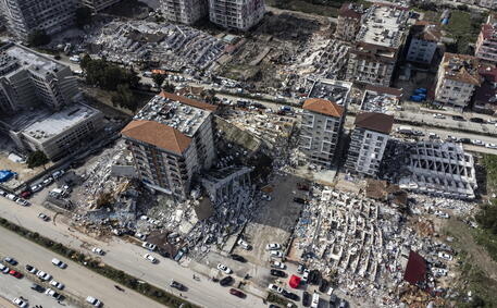 epa10452945 A photo taken with a drone shows a an aerial view over collapsed buildings after an earthquake in Hatay, Turkey, 07 February 2023. Thousands of people died and thousands more were injured after major earthquakes struck southern Turkey and northern Syria on 06 February. Authorities fear the death toll will keep climbing as rescuers look for survivors across the region.  EPA/ERDEM SAHIN